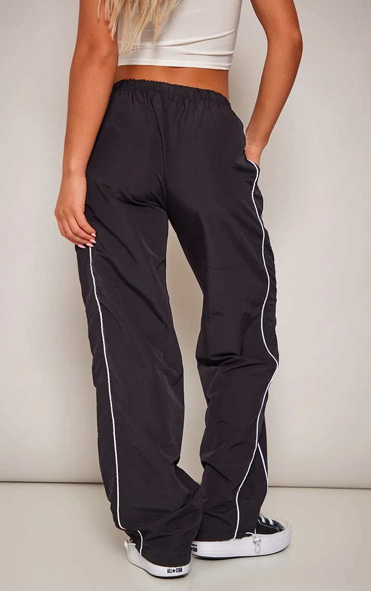 Pantalon de survêtement style parachute noir à liserés et cordons ajustables