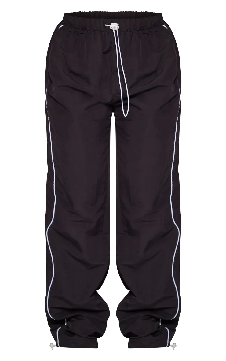 Pantalon de survêtement style parachute noir à liserés et cordons ajustables